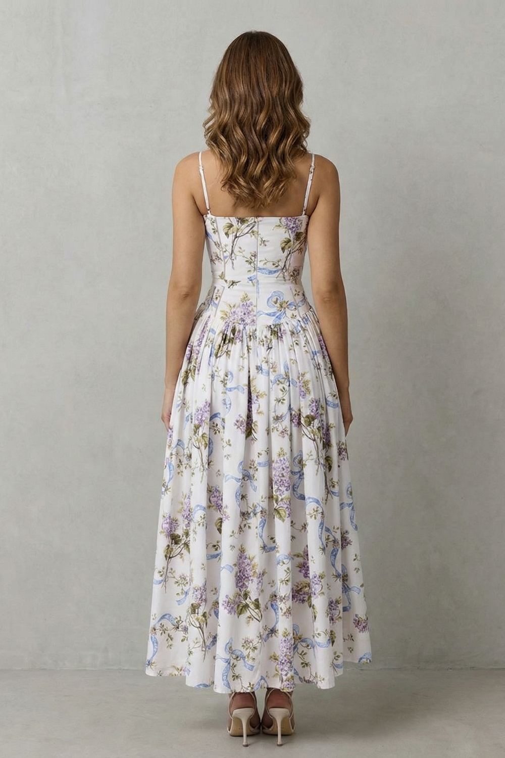Back view of a women's elegant floral midi dress with spaghetti straps and a pleated skirt, ideal for wedding guest dresses.