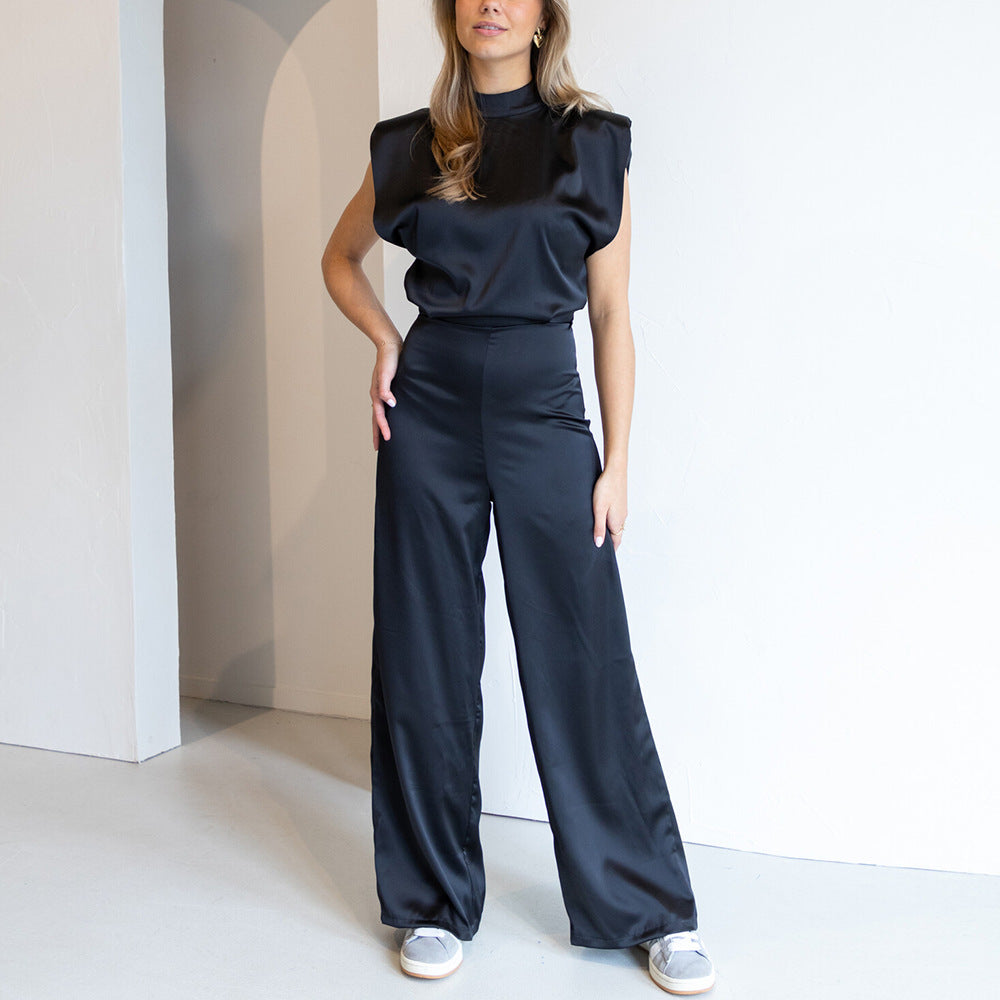 Front view of a black satin high neck wide leg jumpsuit, showcasing the elegant silhouette and padded shoulder detail.
