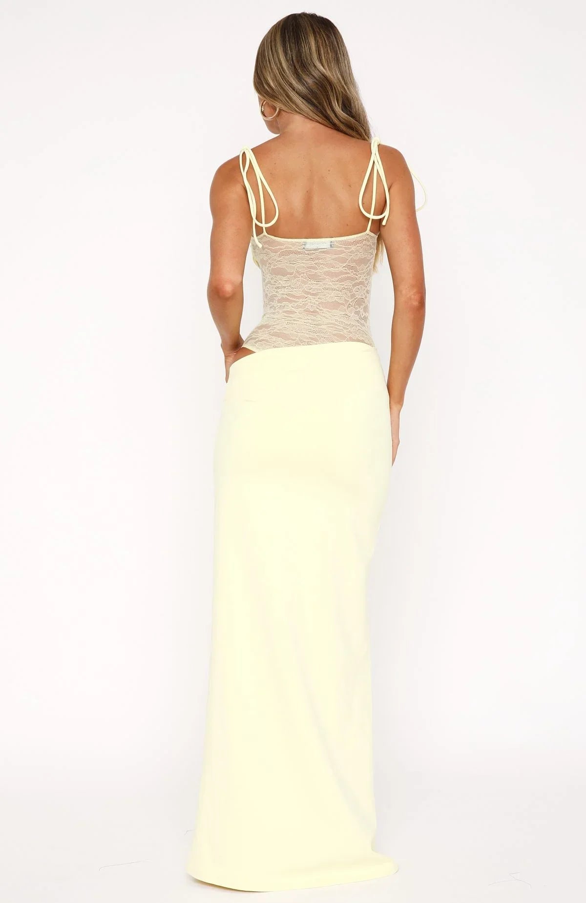 Back view of a light yellow strapless lace cut out maxi dress, showing the intricate lace bodice and the long, elegant skirt, ideal for vacation dresses.