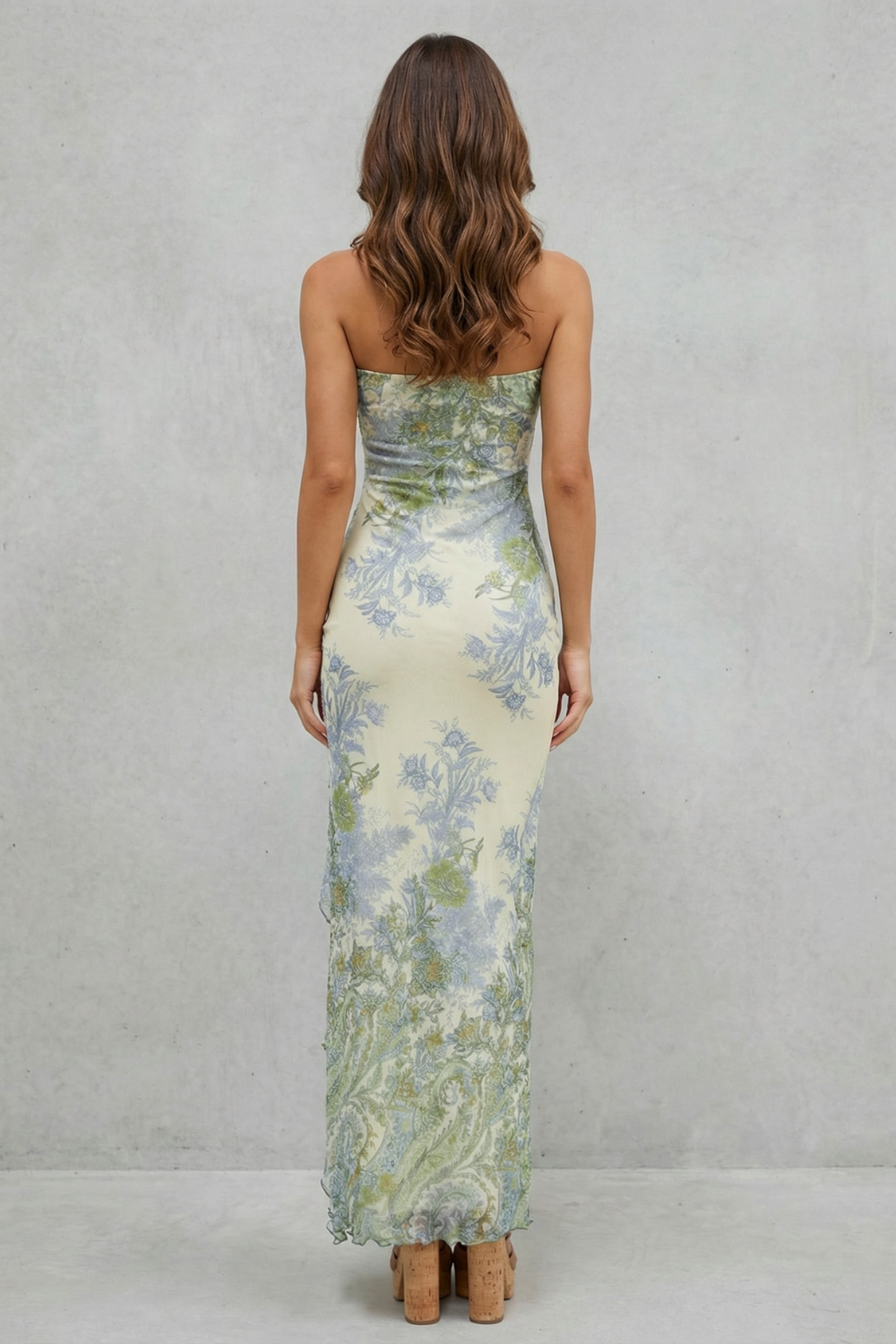 Back view of a strapless cream maxi dress with a blue and green floral print, highlighting the fitted silhouette.