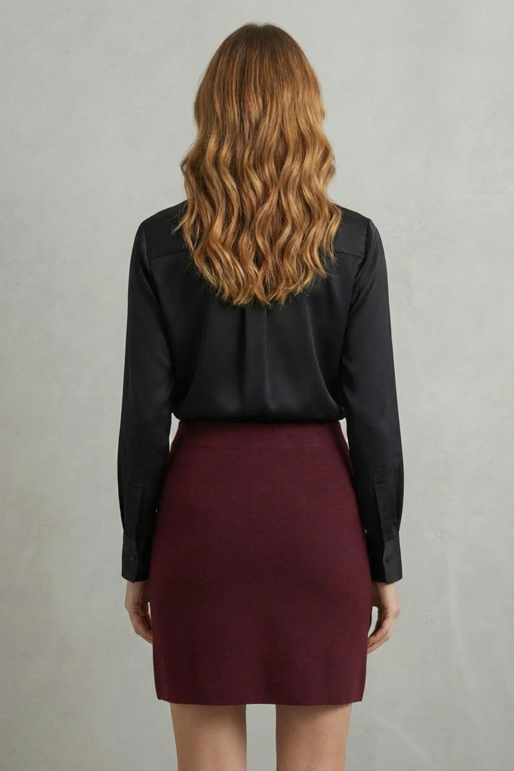 Back view of the women's V-neck long sleeve knit mini skirt set, showing the black satin shirt and maroon knit mini skirt.