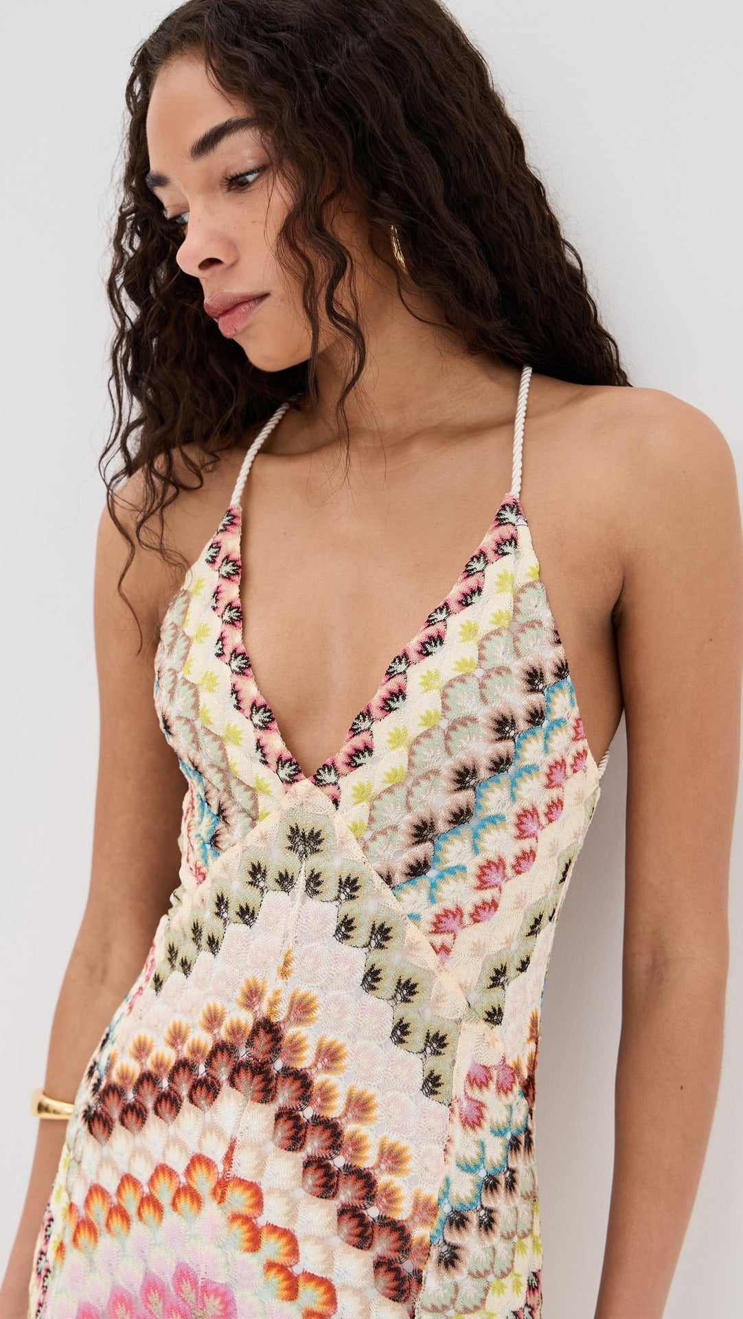 Close-up of the V-neck and intricate chevron embroidery on a women's colorful maxi dress with white straps.