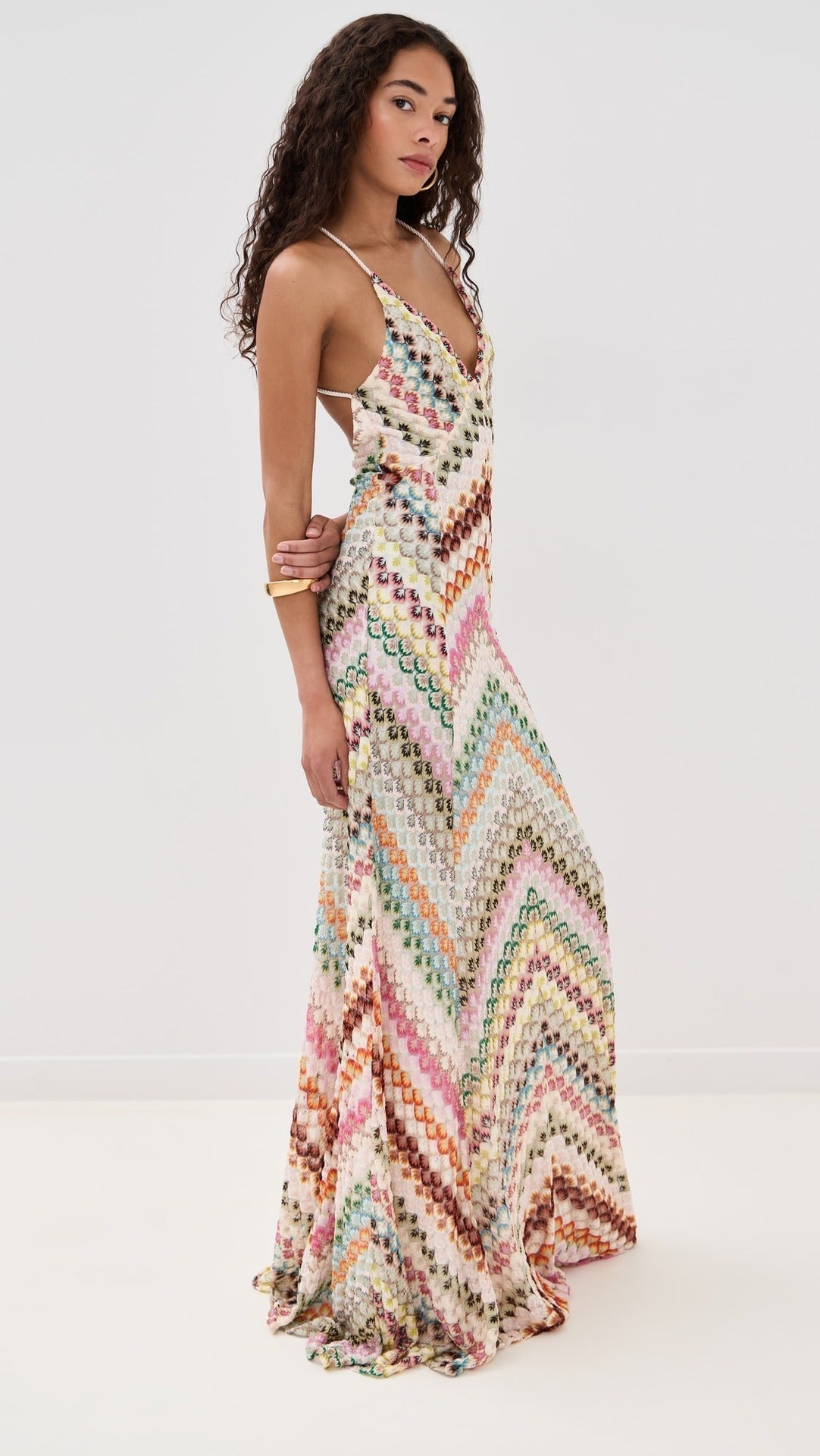 Side view of a women's full-length chevron embroidered V-neck maxi dress, showcasing the flowing skirt and colorful design.