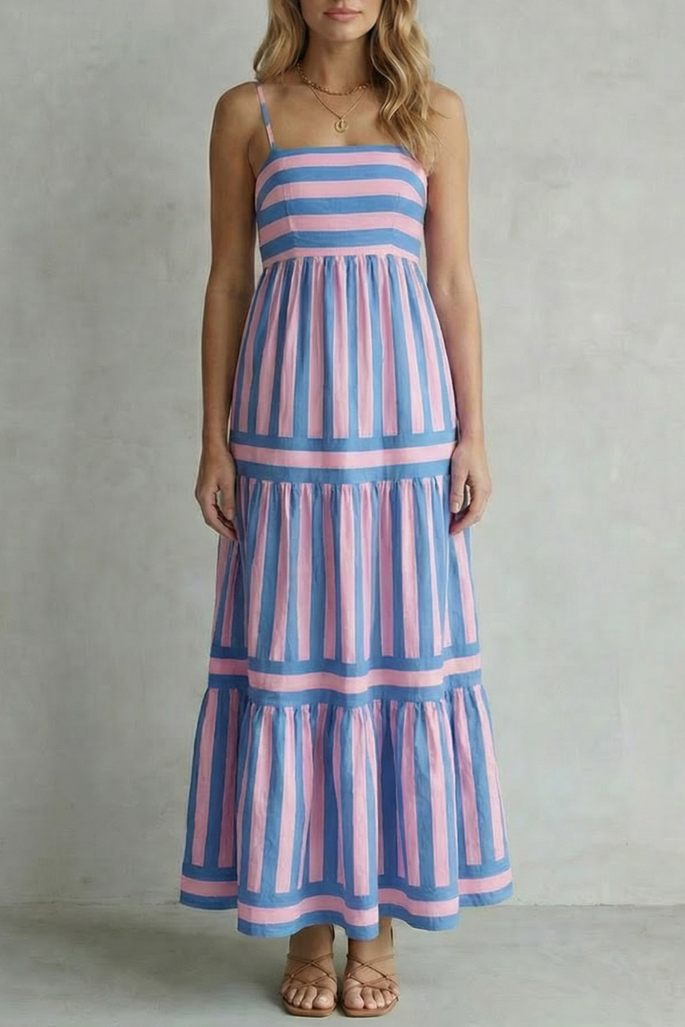 Front view of a blue and pink striped tiered maxi dress with delicate spaghetti straps, ideal for vacation dresses.
