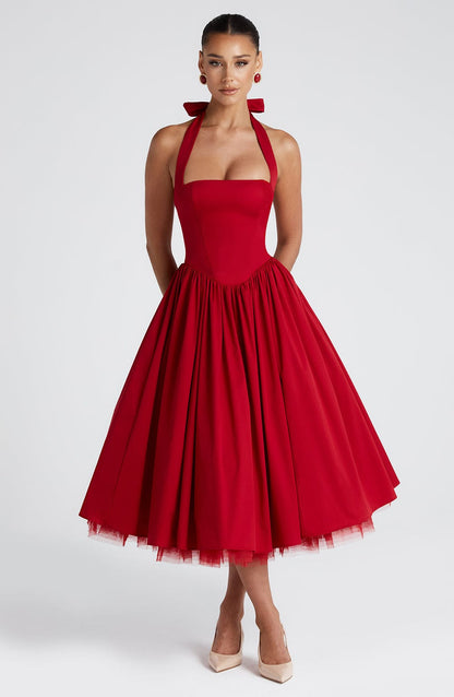 Front view of a red backless halter neck midi dress with a full skirt and visible tulle underskirt.