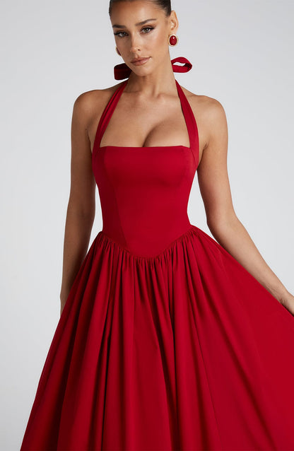 Close-up of the bodice of a red backless halter neck midi dress, showing the square neckline and fitted waist.