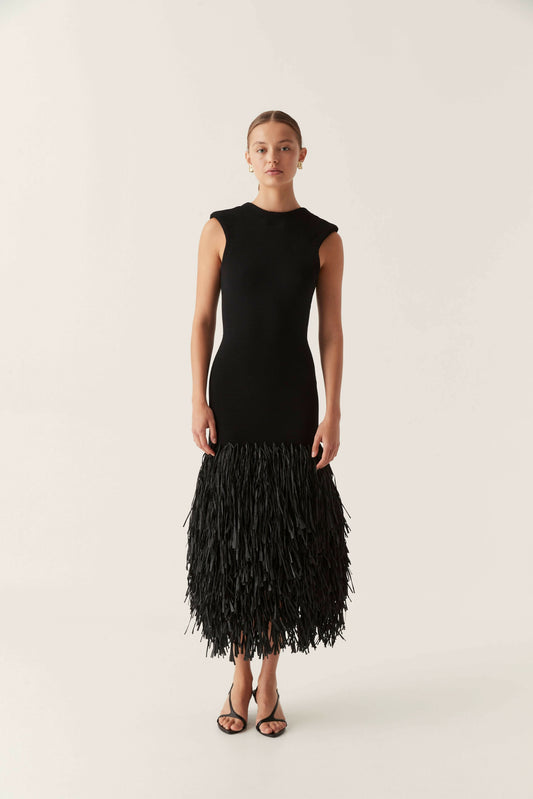 Sleeveless black bodycon maxi dress with a full fringe skirt and backless design, suitable for elegant events.