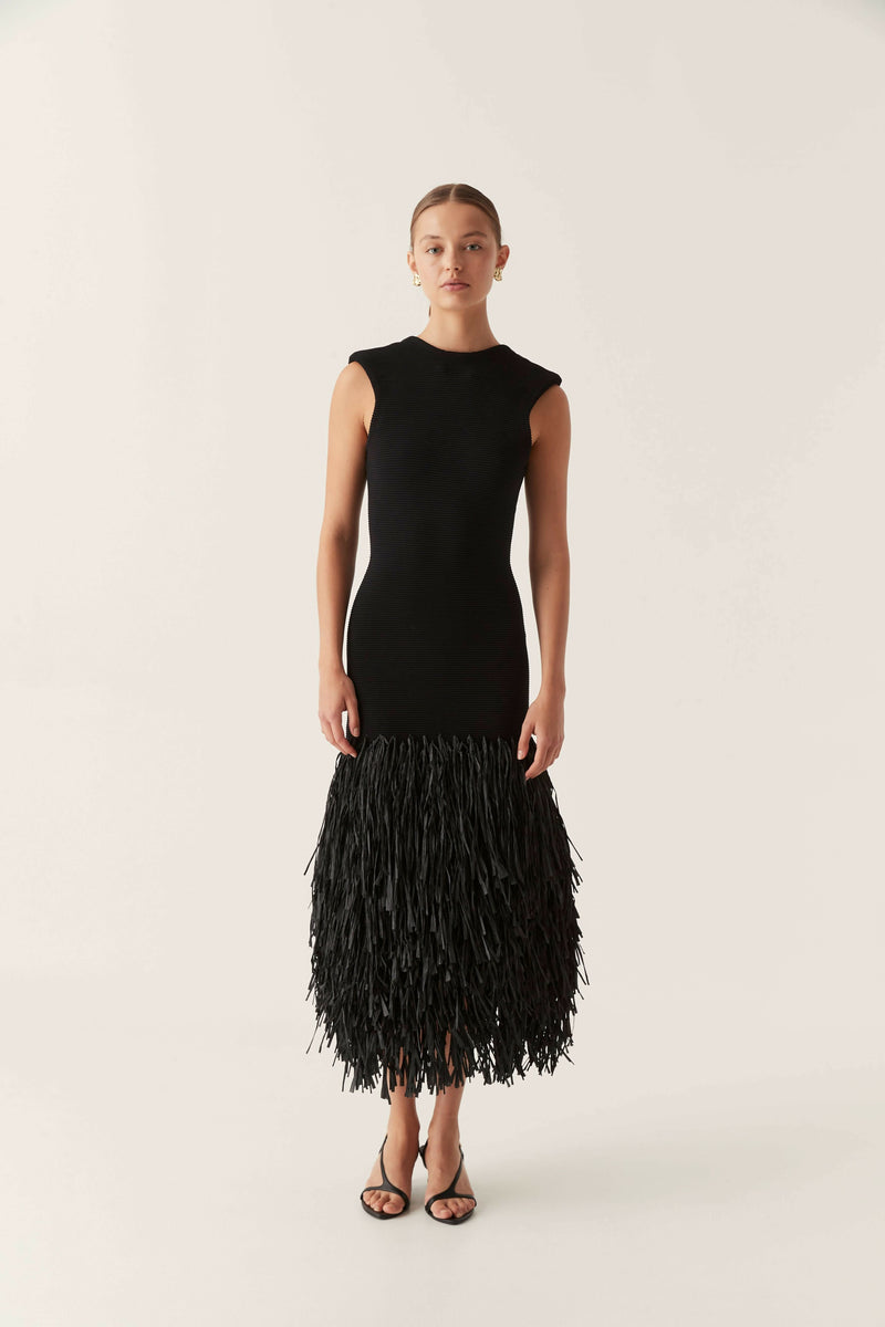 Sleeveless black bodycon maxi dress with a full fringe skirt and backless design, suitable for elegant events.