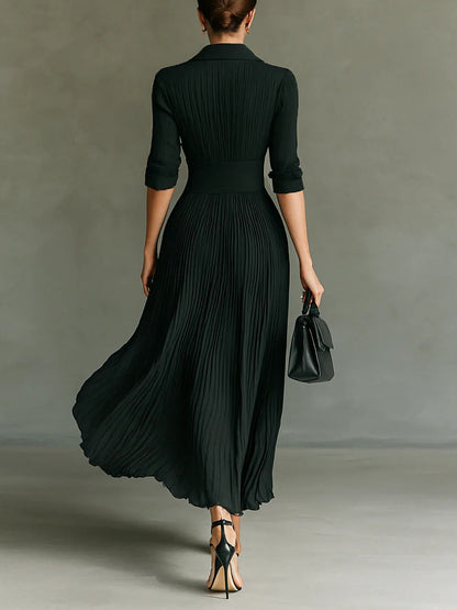 Back view of black long sleeve pleated maxi dress with cinched waist and flowing skirt
