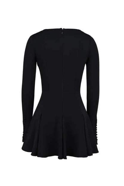 Model from behind wearing the Kouvr Fashion black long sleeve mini dress, showing the button details on the split cuffs