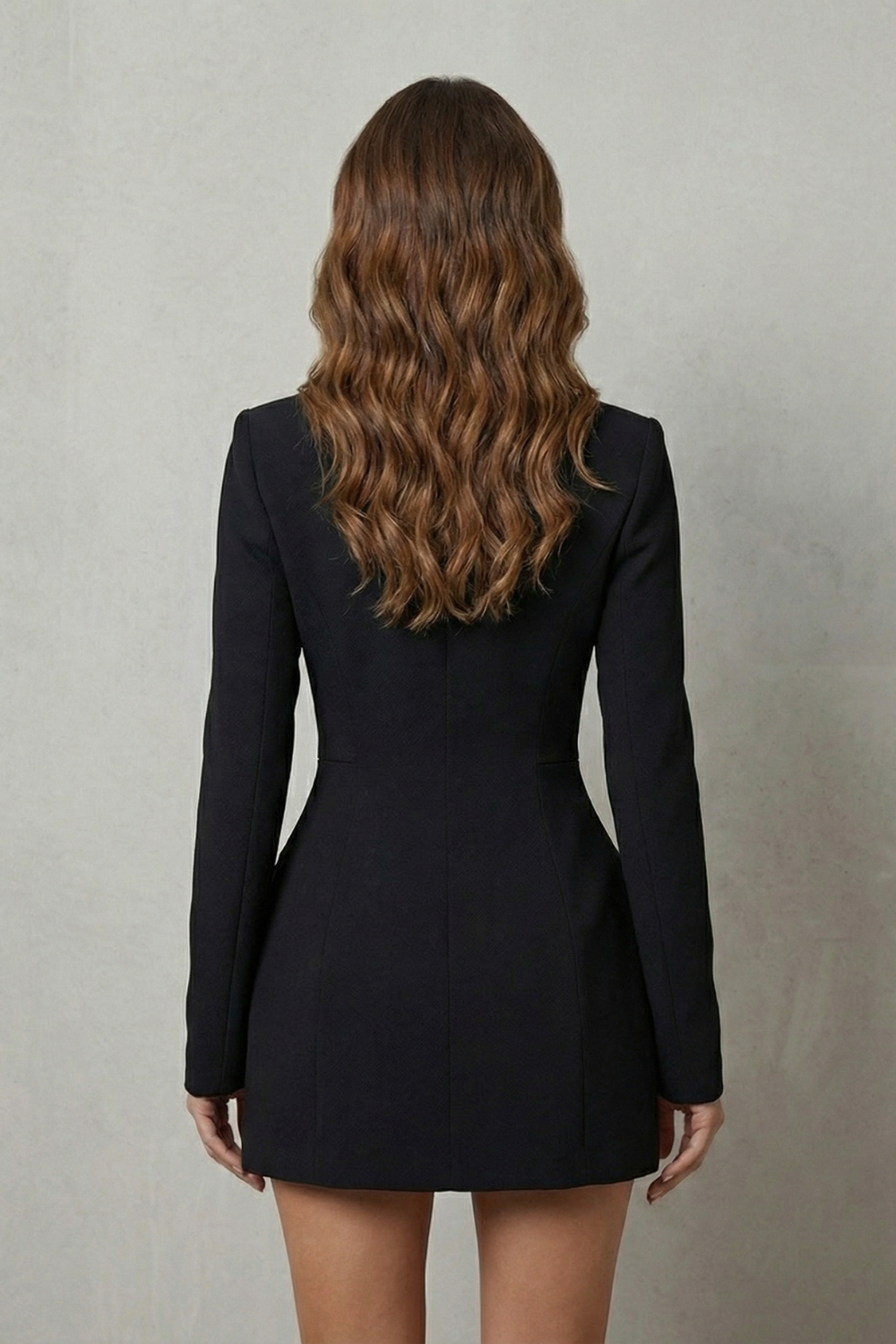 Back view of a black blazer mini dress, highlighting the fitted waist and smooth fabric.