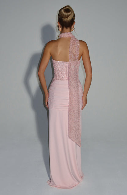 Back view of a blush sequin corset strapless maxi dress featuring a ruched skirt and a long sequin scarf draped over one shoulder.