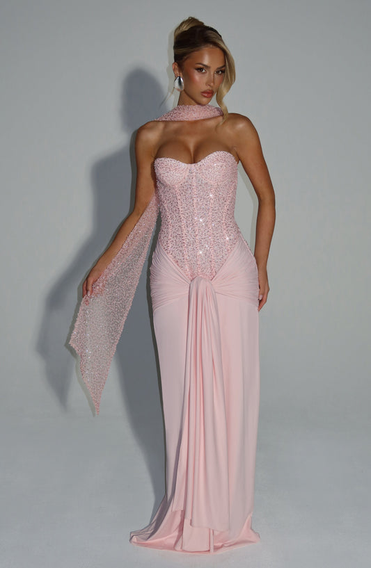 Front view of a blush sequin corset strapless maxi dress with a draped skirt and matching sequin scarf detail, perfect for wedding guests.