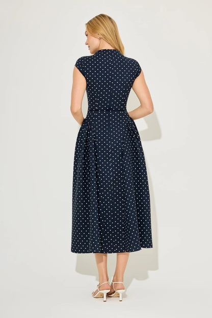Back view of navy polka dot cap sleeve midi dress with gathered skirt and fitted bodice seams