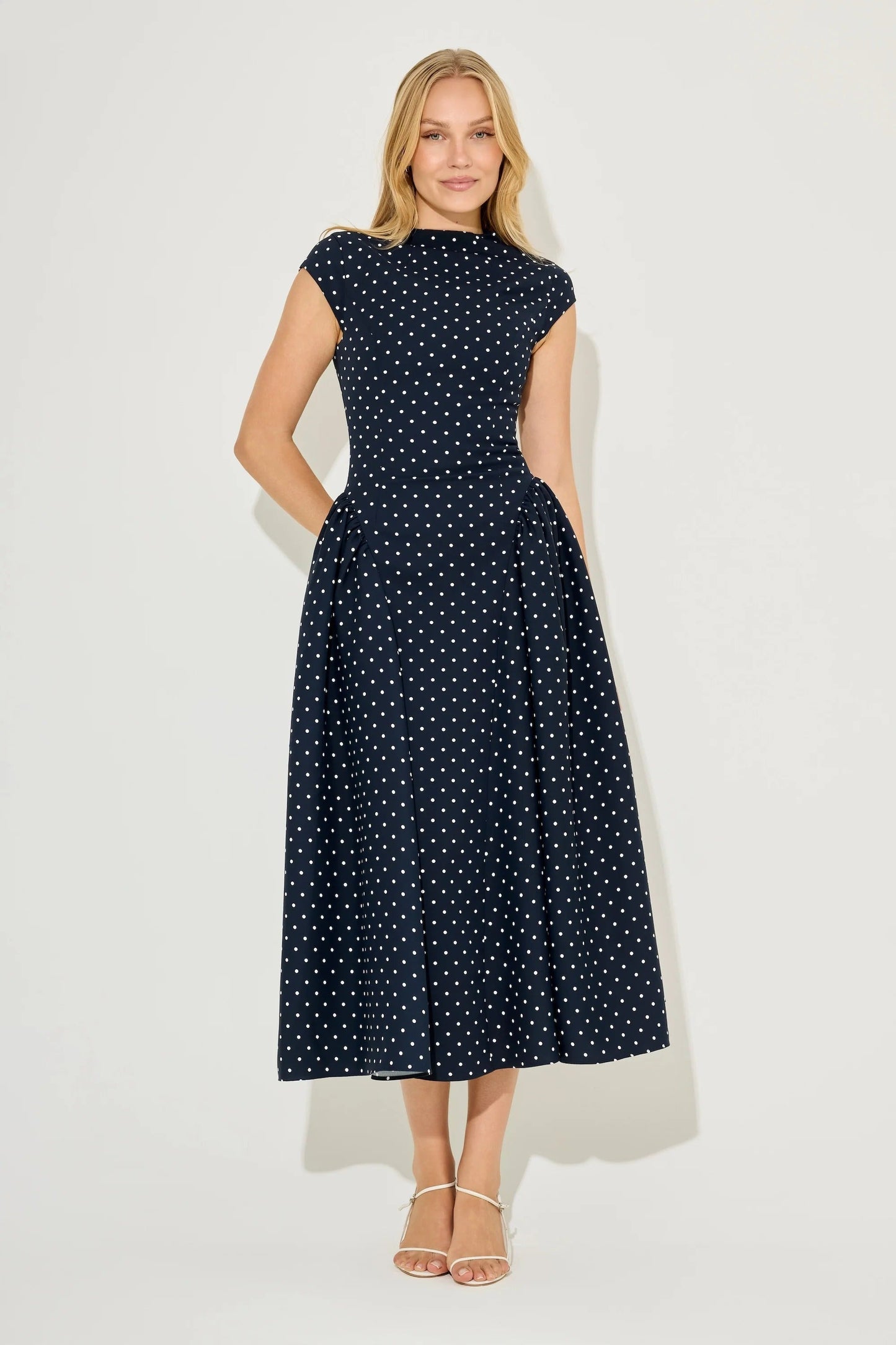 Navy polka dot cap sleeve gathered midi summer dress with fitted bodice and flared skirt