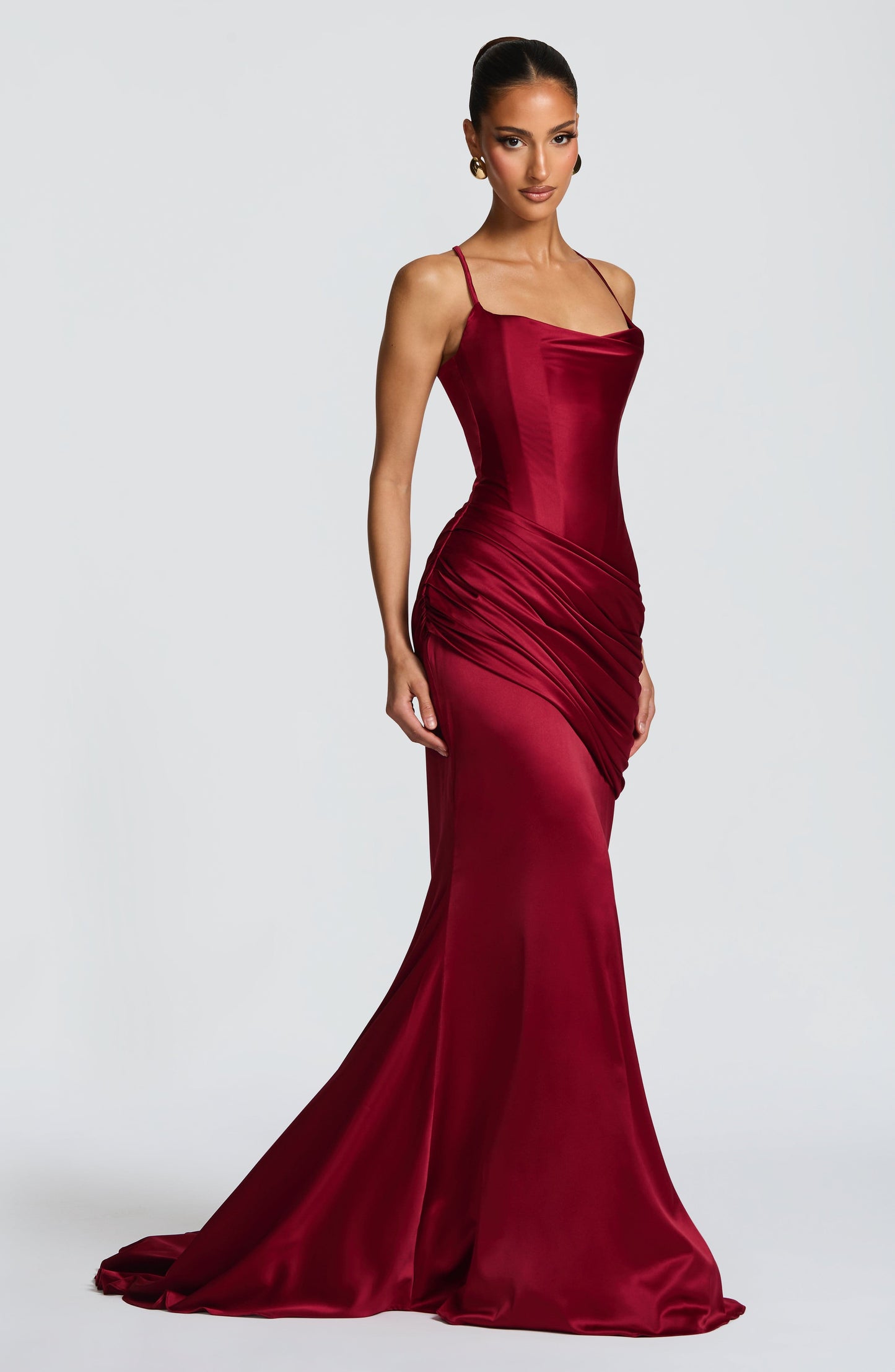 Side angle burgundy satin corset maxi dress with ruched hip drape and floor-length hem