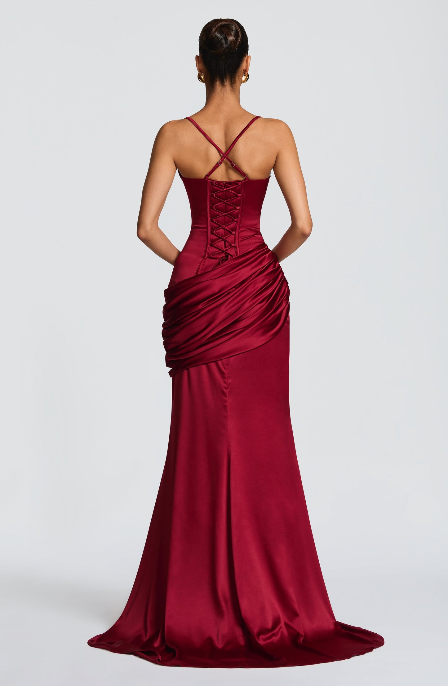 Back view burgundy satin maxi dress showing lace-up corset panel and crisscross straps