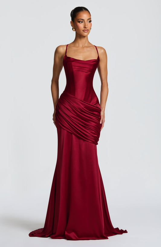 Burgundy satin corset maxi dress with spaghetti straps and draped skirt, wedding guest front view