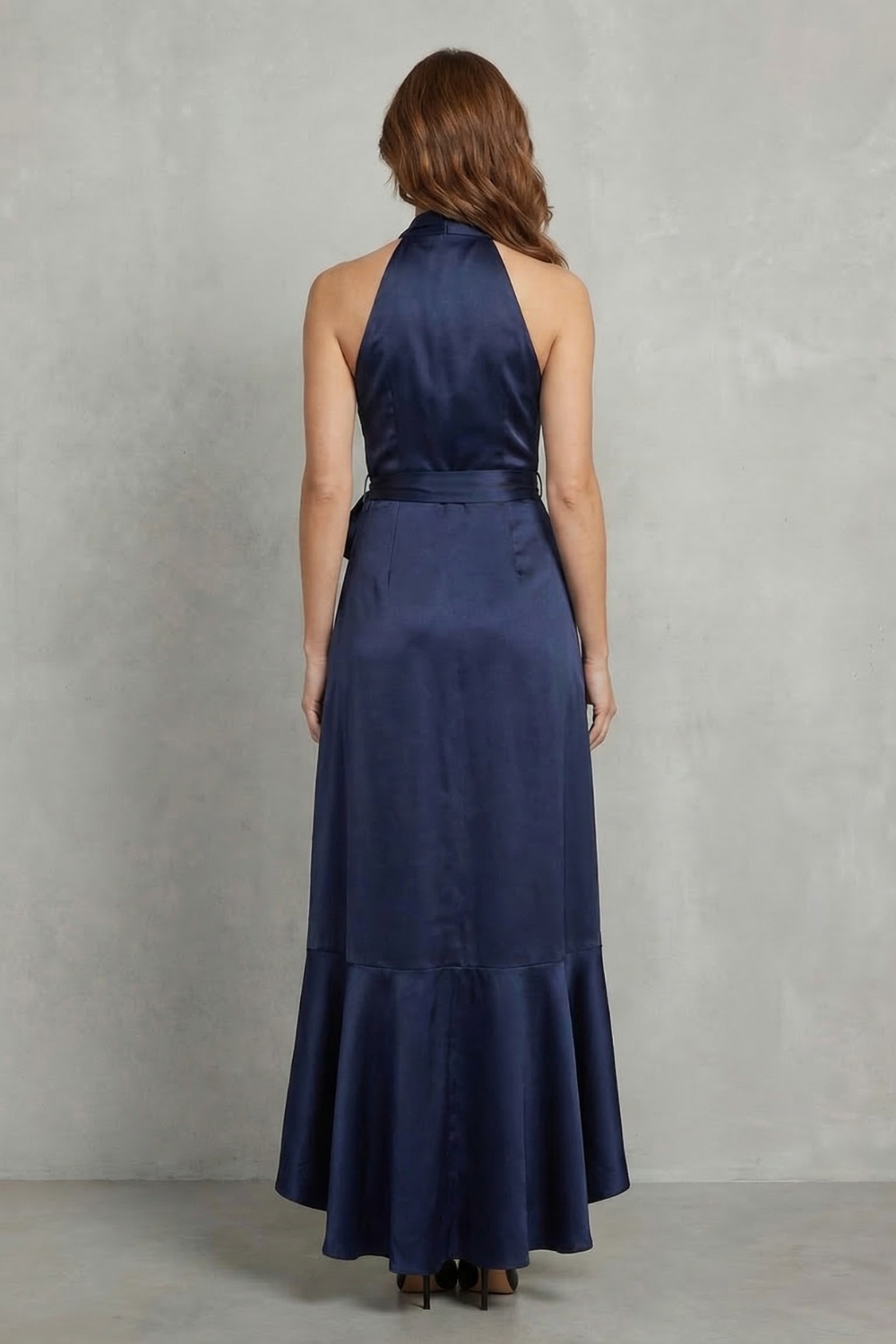 Back view of a navy blue satin halter wrap high-low maxi dress, highlighting the elegant drape and halter neckline.
