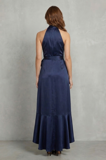 Back view of a navy blue satin halter wrap high-low maxi dress, highlighting the elegant drape and halter neckline.