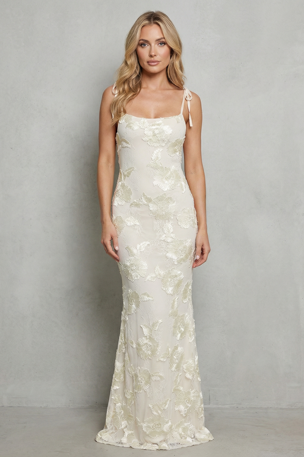 Front view of a beautiful white floral appliqué scoop neck maxi dress with tie-up shoulder straps, perfect for vacation.