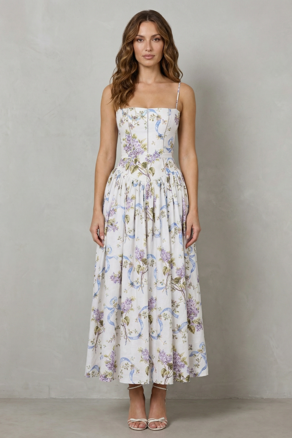 Front view of a women's floral midi dress with a structured corset bodice and thin straps, perfect for vacation outfits.
