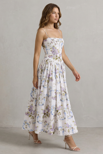 Side profile of a women's floral midi dress, showcasing the flowing skirt and fitted corset bodice, suitable for wedding guests.