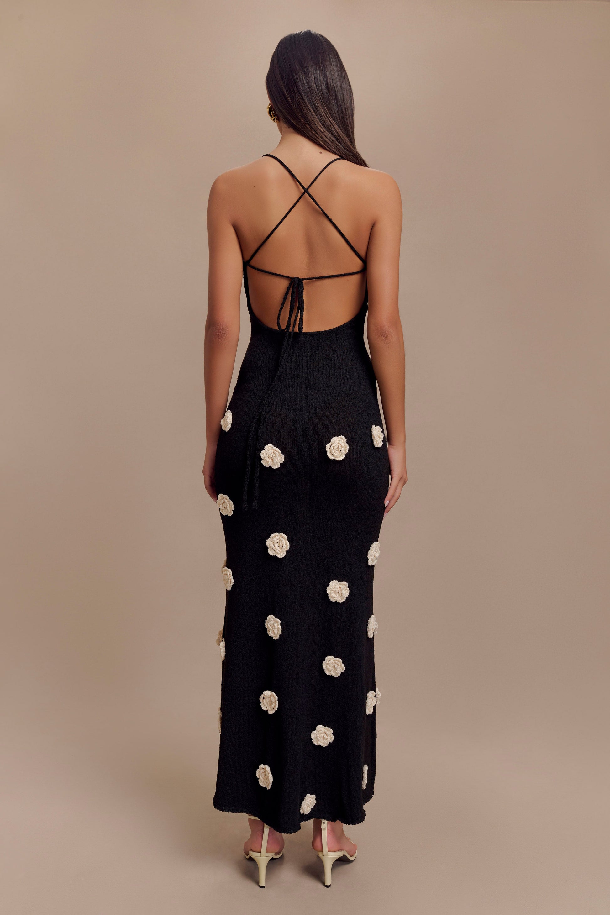 Back view of black floral crochet maxi dress with criss-cross adjustable straps and tie closure