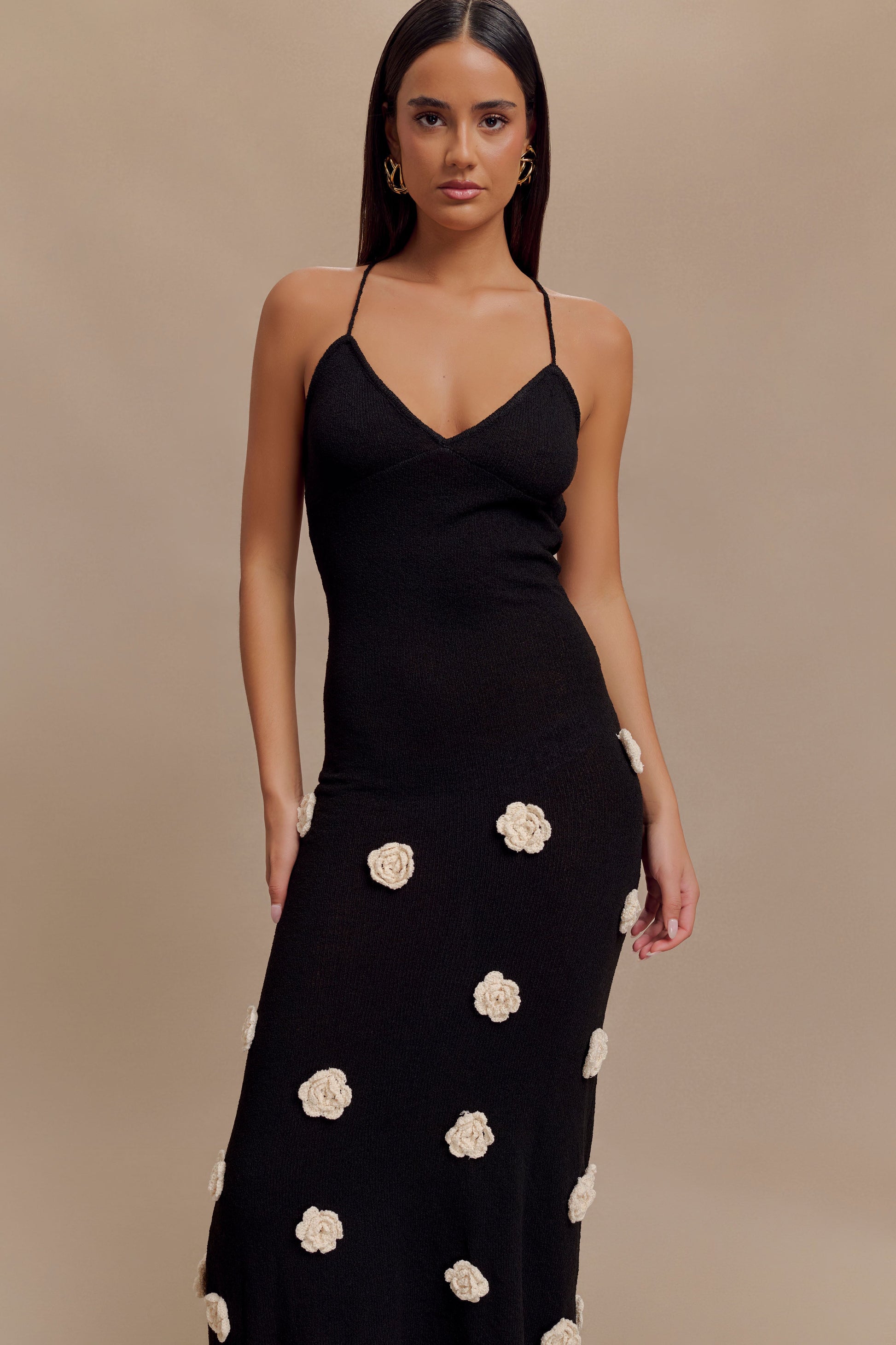 Close-up front view of black knit floral crochet maxi dress, highlighting the v-neckline and texture