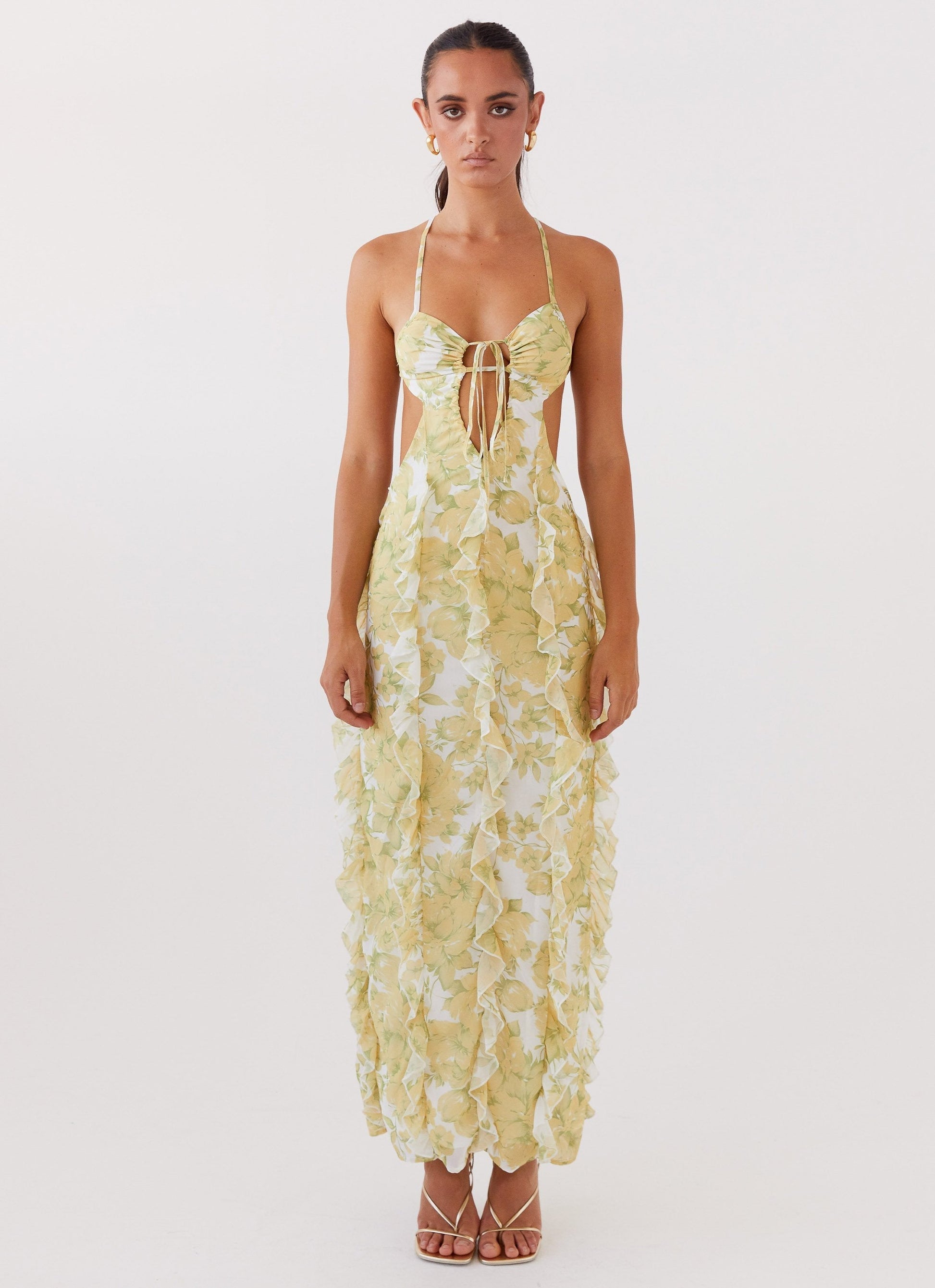 Studio shot of women's floral cut out ruffle tie front maxi dress, front view, highlighting the tie-front bodice.