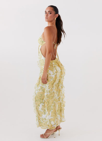 Three-quarter back view of women's floral cut out ruffle tie front maxi dress, highlighting the side cut-out and back straps.