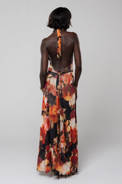 Back view of the floral halter maxi dress in orange and red, highlighting the tie-neck detail and open back design, an elegant dress for wedding guests.
