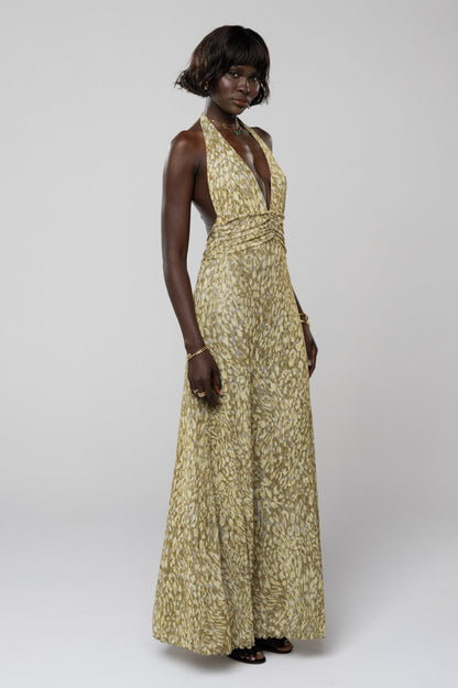 Side profile of the green and yellow abstract print halter maxi dress, showing the elegant drape and flattering cut, a beautiful vacation dress.
