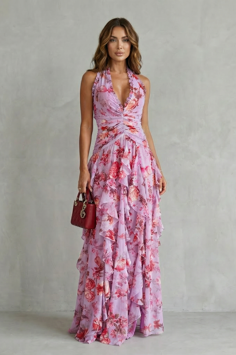 Front view of a woman wearing a lavender floral halter maxi dress with ruched bodice and cascading ruffles.