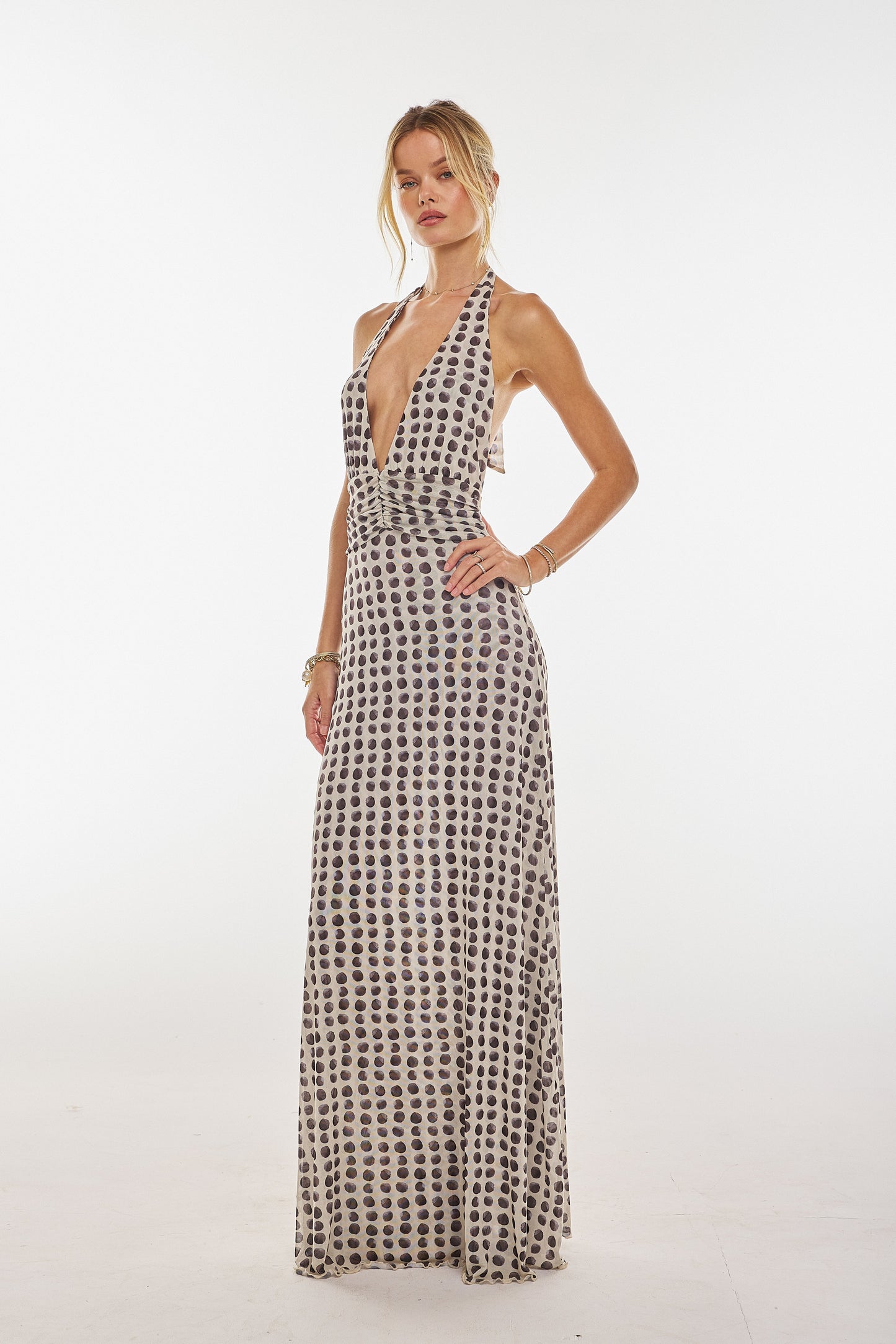 Women's halter maxi dress in a white and black polka dot pattern, with a deep v-neck and fitted bodice, a stylish option for a wedding guest dress.