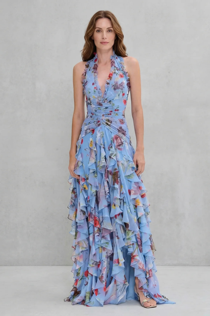Front view of a woman wearing a light blue floral halter maxi dress, showcasing the full length and ruffled design.