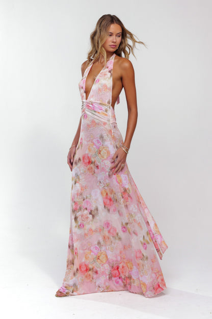 Dynamic side view of a women's pink floral halter maxi dress, showing the full length and elegant flow.