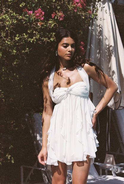 White halter neck mini dress with ruffled tiered skirt and star embellishment, perfect for vacation outfits.