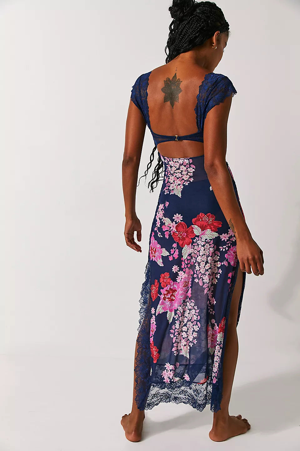 Back view of a navy floral lace cut out back maxi dress with pink and red flowers, featuring high leg slits and a lace trim.