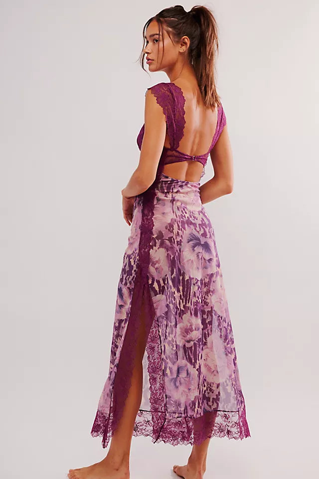 Back view of a purple floral lace cut out back maxi dress, showing the cut out detail and high side slit with lace trim.