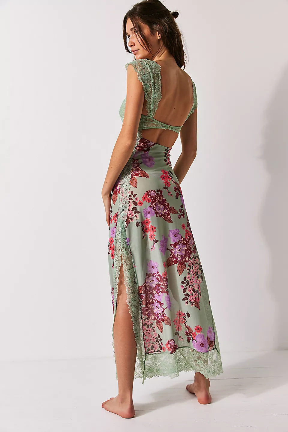 Back angled view of a women's sage green floral lace cut out back maxi dress with a high leg slit, ideal for vacation outfits.