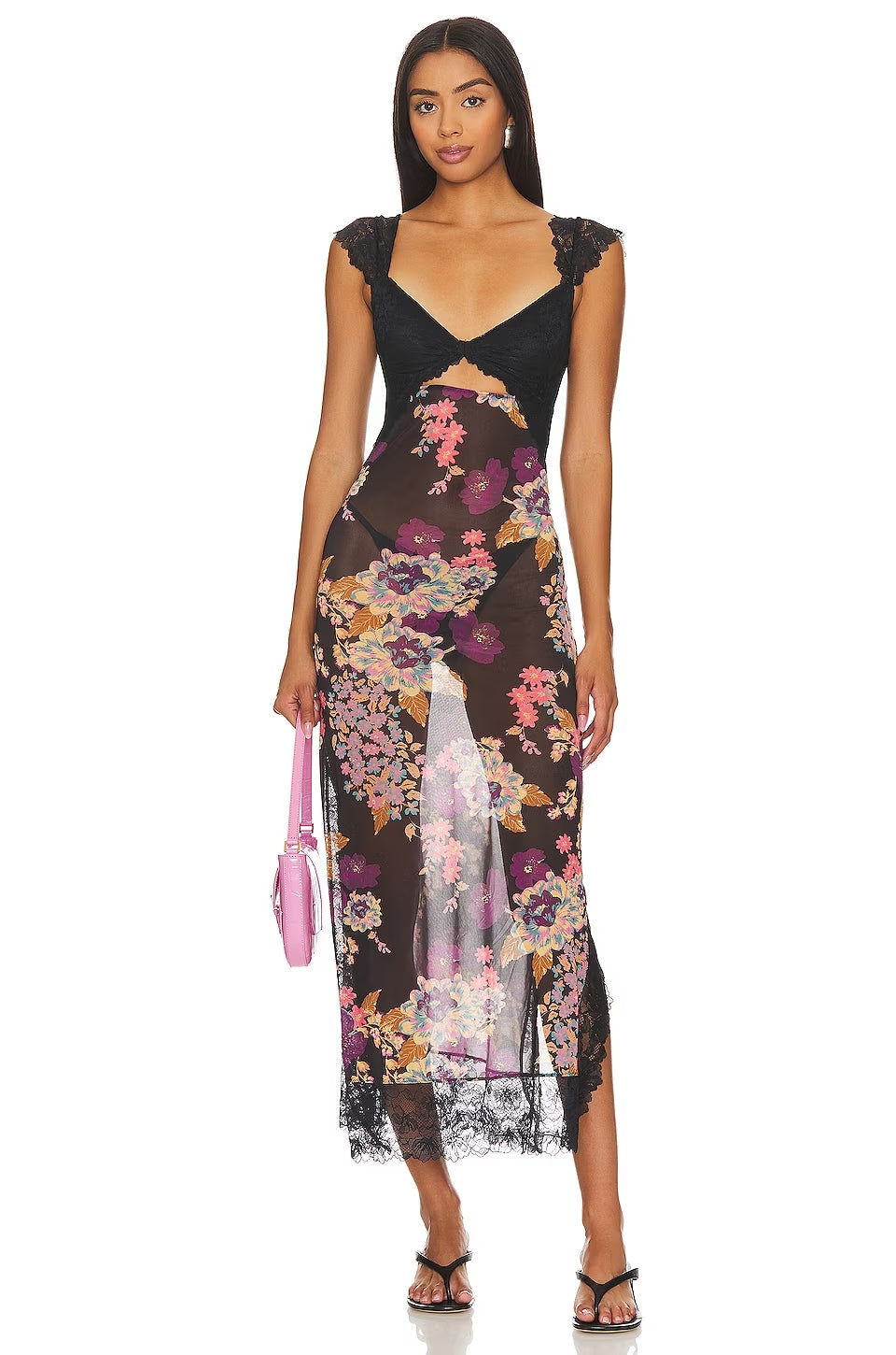 Front view of a women's black floral lace cut out back maxi dress with a colorful floral print and a pink handbag, perfect for a wedding guest dress.
