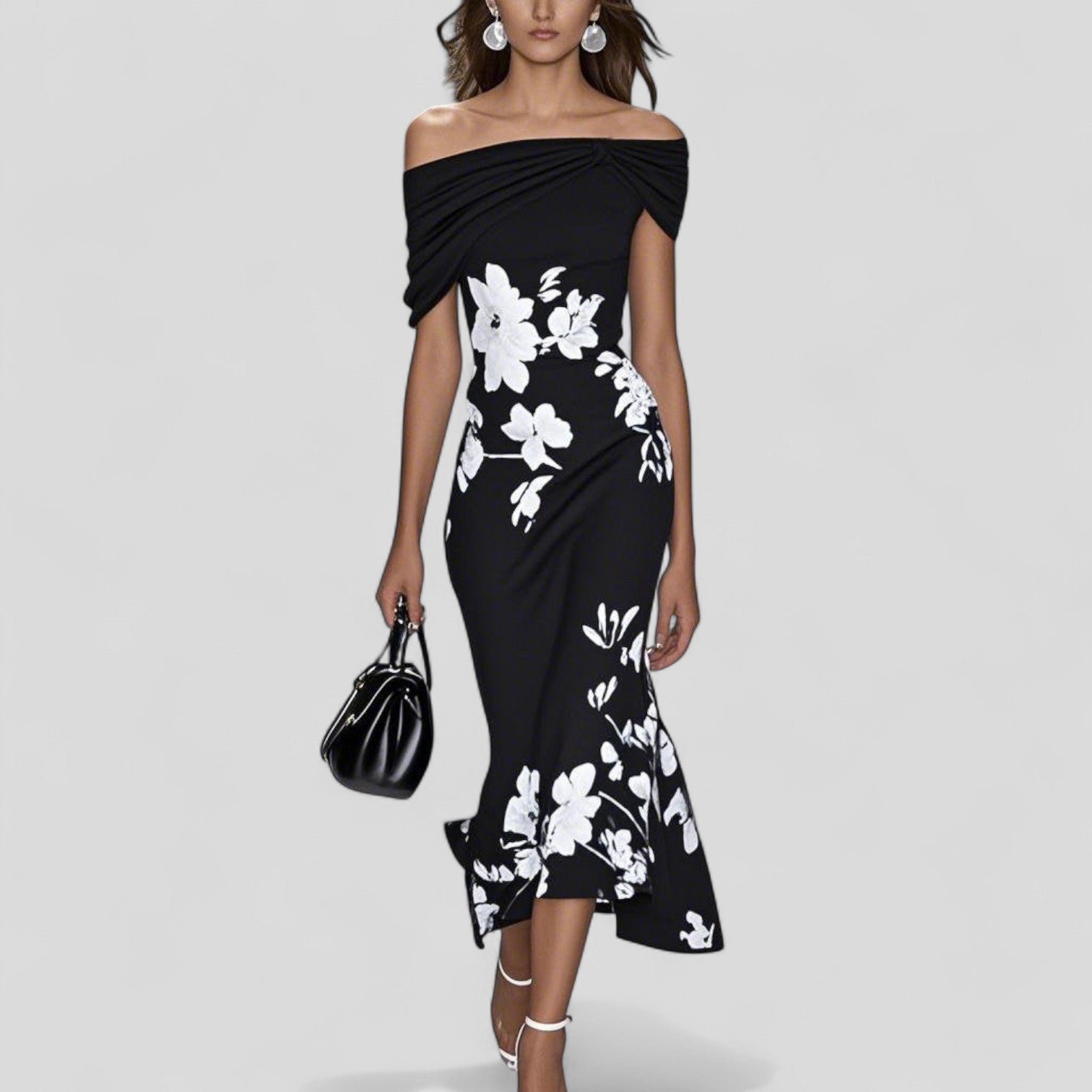 Black off-shoulder midi dress with white floral print, twisted bodice, and a high-low mermaid skirt. Stylish wedding guest dress.