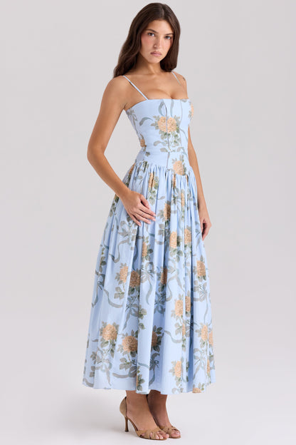 Side view of a women's light blue floral midi dress with a square neckline and delicate straps, showcasing the full skirt and floral pattern.
