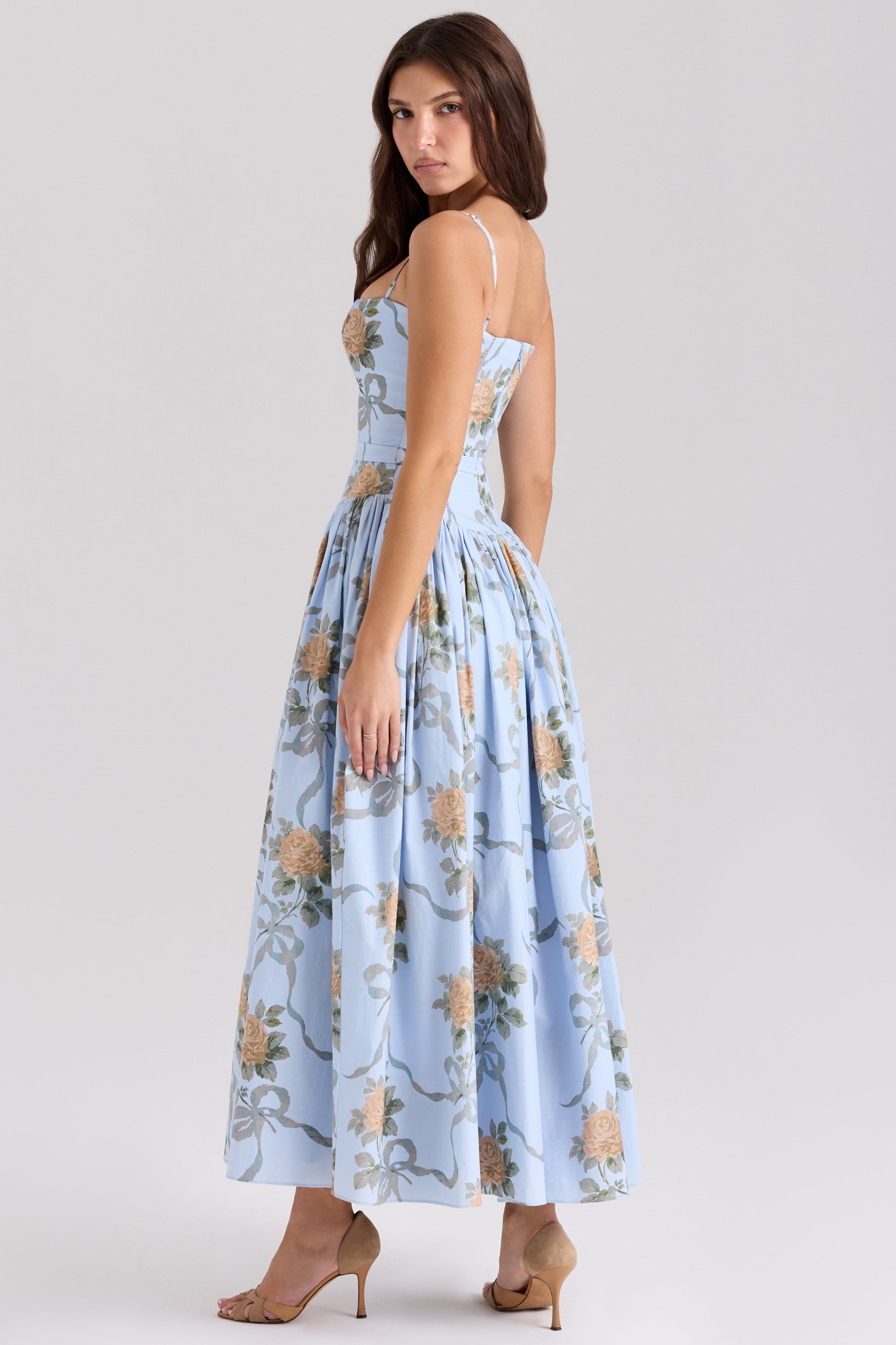 Back three-quarter view of a light blue floral printed square neck midi dress, highlighting the elegant silhouette and rose pattern, ideal for wedding guest dresses.