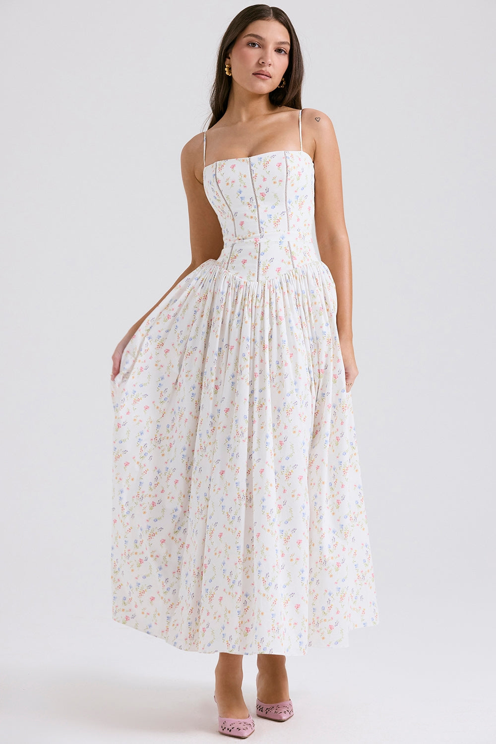 Front view of a women's white midi dress with a delicate multi-color floral print, square neck, and spaghetti straps.