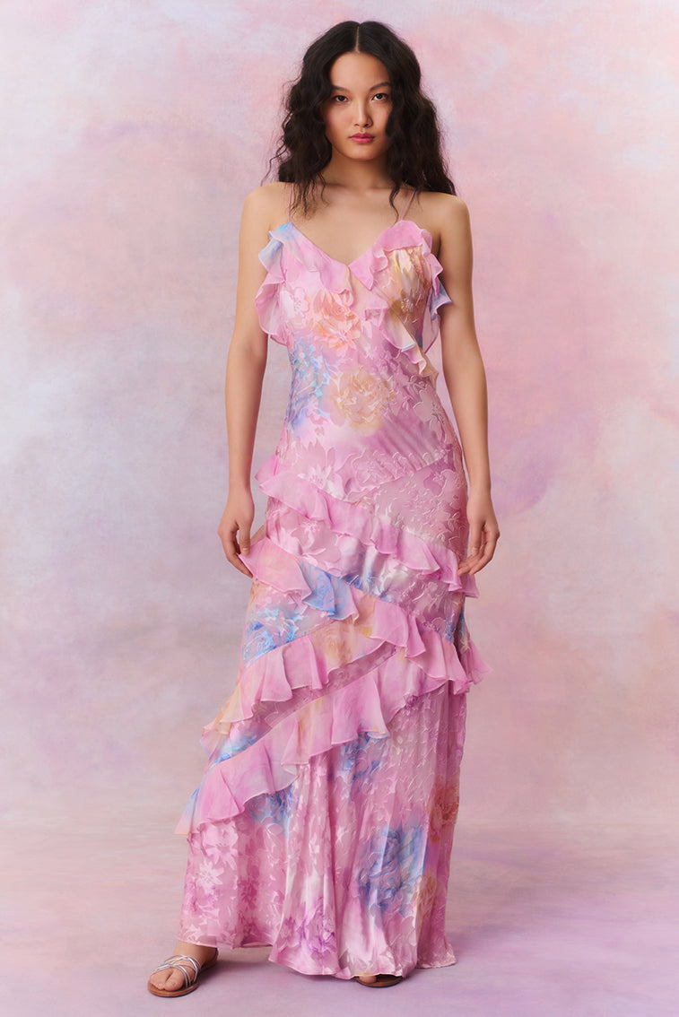 Front view of a women's floral ruffle strap maxi dress in pink with blue and yellow floral accents, a lovely vacation dress.