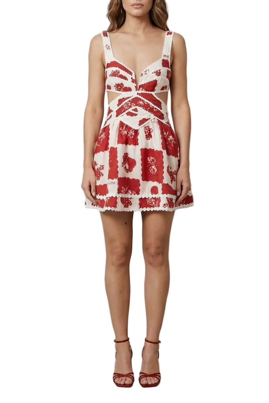 Front view of a women's red and white floral mini dress with a deep V-neck and side cut-outs, featuring scalloped trim.