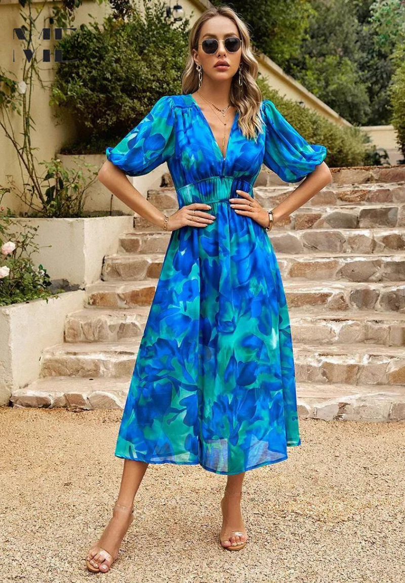 Women's blue and green floral v-neck midi dress with short puff sleeves and a smocked waist, suitable for elegant dresses for wedding guests.
