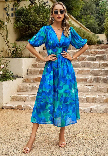 Women's blue and green floral v-neck midi dress with short puff sleeves and a smocked waist, suitable for elegant dresses for wedding guests.